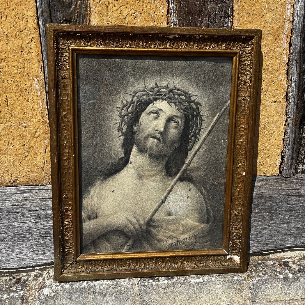 Framed artwork of a religious figure with a crown of thorns and a staff against a rustic wooden background.